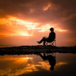A person reading on a chair by a reflecting pond at sunset in Korgan, Turkey.
